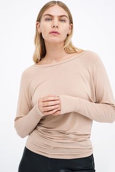 Our Sophia Top is designed to be fitted on the hips and looser up top, making the most of her wide boat neckline and subtle batwing sleeves. A day-to-night staple piece, she's fashioned from soft and high-stretch sheer European jersey for a comfortable fit and elevated feel. Her beautifully versatile neckline can also be worn off one shoulder, while her extra-long sleeves with thumbholes add edge.[SPLIT] Maritza, in light beige, is 5'9" (177 cm) tall, wearing size XS. Astrid, in black, is 5'9" ( Oversized Off-shoulder Loungewear Top, Chic Slouchy Top With Crew Neck, Chic Solid Color Tops With Scoop Back, Chic Solid Tops With Scoop Back, Chic Stretch Tops With Scoop Back, Elegant Stretch Top With Scoop Back, Chic Oversized Boat Neck Top, Elegant Spring Top With Scoop Back, Elegant Scoop Back Top For Spring