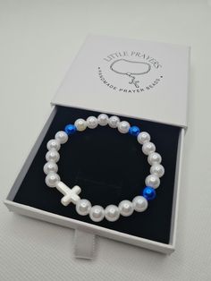 Handmade prayer bead elasticated bracelet ☆ White and royal blue pearl beads ☆ White pearl Cross bead ☆ Logo box for safe keeping  Handmade in Scotland, Little Prayers, prayer beads are perfect for those little moments throughout your day. Through your hard times or times you want to give your thanks these beads will be the perfect tool for your prayers. Little Prayers are hand made one by one with love and hope that they will bring you comfort and happiness. Gift Rosary Bracelet With Round Pearl Beads, Gift Pearl Rosary Bracelet With Round Beads, Pearl Rosary Bracelet With Round Beads Gift, Pearl Beaded Bracelets With 8mm Beads As A Gift, Spiritual Pearl Bracelet With Round Beads, Adjustable Pearl Rosary Bracelet Gift, Pearl Rosary With 8mm Beads As Gift, Blue Pearl Beaded Bracelets For Gifts, Pearl Rosary With Round Beads As Gift