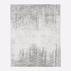 a gray and white area rug with an abstract design on the bottom, in front of a light grey background