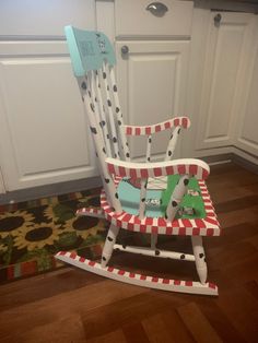 a wooden rocking chair with a green toy horse on it's seat in a kitchen