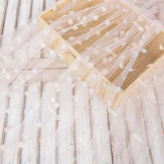 a piece of fabric sitting on top of a white wooden floor covered in confetti