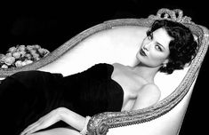 a black and white photo of a woman laying on a couch