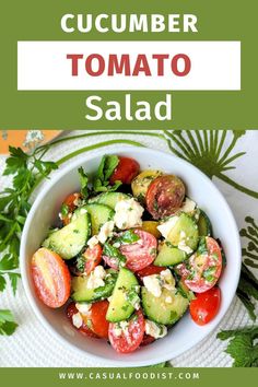 cucumber tomato salad with feta cheese and tomatoes in a white bowl on a table