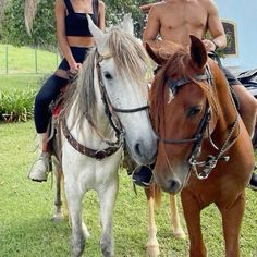 a man and woman riding on the backs of horses