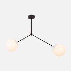 three lights hanging from the ceiling with one light on it's side and two white balls