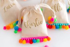 three small bags with pom poms on them