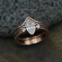 two wedding rings with diamonds sitting on top of a rock