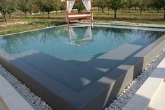 an empty pool surrounded by stones and trees