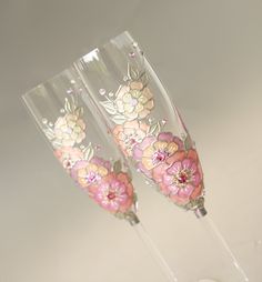 two champagne flutes with flowers painted on them