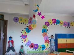 three children are standing in front of a wall with numbers and stars painted on it