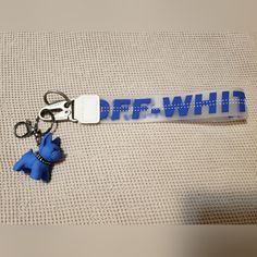 a keychain with a blue dog on it that says,'off - whine '