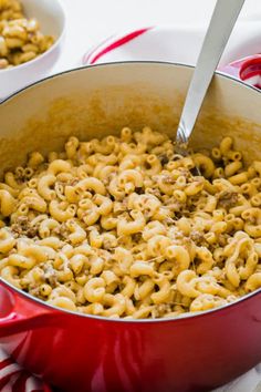 a red pot filled with macaroni and cheese