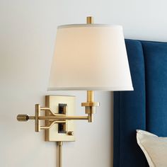 a lamp on a wall next to a blue couch