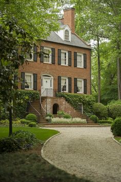 a large brick house surrounded by trees and bushes