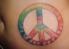 a peace sign tattoo on the back of a woman's lower body, painted in tie - dye