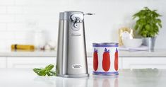 an electric juicer sitting on top of a counter next to a can