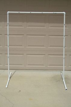 a white soccer goal sitting in front of a garage door