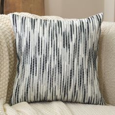 a black and white striped pillow sitting on top of a couch