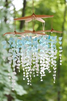 a wind chime hanging from a tree in the woods