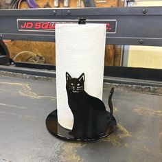 a toilet paper holder with a black cat on it