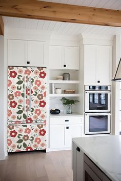 a kitchen with white cabinets and floral wallpaper on the doors, stoves and refrigerator