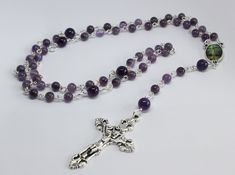 A beautiful five decade rosary made using 6mm and 8mm amethyst gemstone beads. The crucifix measures 4cm by 2.5cm. Wrapped in tissue paper and presented in an organza gift pouch. Please note the medal may differ from the one pictured. Purple Rosary With 8mm Round Beads, Purple Rosary With 8mm Beads, Purple Beaded Rosary As Gift, Handmade Spiritual Purple Rosary Bracelet, Chaplet Rosary, Decade Rosary, Rosary Beads Catholic, Catholic Jewelry, Catholic Rosary