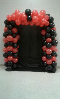 a black and red balloon arch with balloons