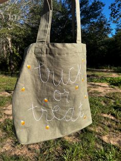 a canvas bag with the words trick or treat written on it hanging from a clothes line