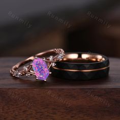 two wedding rings with pink opal and white diamonds on them sitting on a wooden table