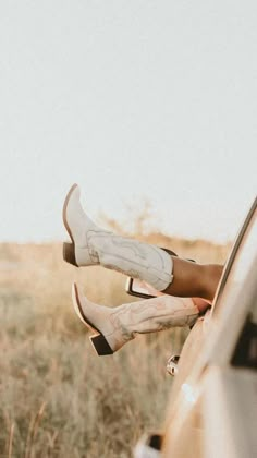 a woman's legs sticking out the window of a car