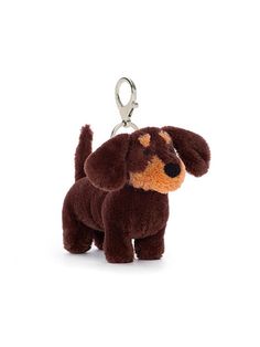 a brown dog keychain sitting on top of a white surface with a black nose