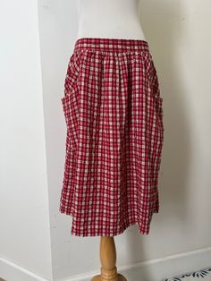 "This is a beautiful skirt by 1990's Guess Red and off white plaid color skirt cotton feel, unlined, two pockets on sides  Marked Size XL Runs smaller (my mannequin is size 4, it fits size 6-8 contemporary US sizes Condition: great vintage condition Measurements (flat) Waist: 30\" Hips: 23\" Overall length: 25\"" Cotton Skirt With Pockets For Daywear, Red Full Skirt Bottoms With Pockets, Retro Cotton Skirt With Pockets, Red Full Skirt With Pockets, Red Skirted Bottoms With Pockets, Plaid Skirt With Pockets, Plaid Cotton Lined Skirt Bottoms, Plaid Cotton Skirted Bottoms, Gingham Gathered Cotton Skirt