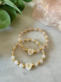 - The cutest little girl initial bracelet. This delicate and dainty initial beaded bracelet has a freshwater shell heart initial with 18k gold filled and gemstone beads. A perfect and sweet personalized new baby gift or toddler bracelet. Beaded on high quality stretch cord and secured. - 4mm 18k gold filled beads   5mm gemstone beads ( white jade, rose quartz) ‼️Young children MUST be supervised at all times while wearing jewelry. Contains small parts that could be a potential choking hazard. Jewelry should always be removed during sleep. Never leave young children unattended with our products. Supervision is required. It is at the customers discretion for the use of our products.  - Each purchase is sent in a velvet drawstring jewelry bag, making the perfect 1st birthday personalized gift Personalized Pink Dainty Beaded Bracelets, Personalized Dainty Charm Bracelet With Round Beads, White Hypoallergenic Dainty Name Bracelet, Dainty Adjustable Name Bracelet With Initials, Dainty Beaded Name Bracelet, Personalized Adjustable Dainty Pearl Bracelet, Delicate White Personalized Bracelets, Delicate Personalized White Bracelets, Dainty Letter Beads Beaded Bracelets For Birthday