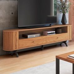 a flat screen tv sitting on top of a wooden entertainment center in a living room