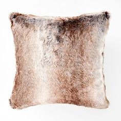 a brown and white fur pillow on a white background