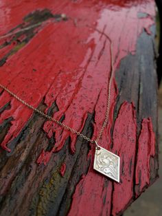 This sweet sterling silver pendant is an adorable everyday statement peice! It features beautiful hand-engraved swirls on a fun diamond shape made out of sterling silver.  Individual pieces may vary slightly from the pictured item. We make each piece by hand, one at a time, for every order. Because of this, your final piece may vary slightly from the picture and the engraving style may be adjusted slightly to fit your ring size or customizations. Please allow at least 5 to 6 weeks for shipment. Silver Etched Necklace With Flower Pendant, Etched Sterling Silver Pendant Necklace, Silver Diamond-shaped Jewelry, Silver Etched Square Pendant Necklace, Stamped Sterling Silver Pendant Jewelry, Elegant Stamped Flower Pendant Necklaces, Sterling Silver Engraved Square Pendant, Elegant Stamped Flower Pendant Necklace, Engraved Sterling Silver Square Pendant Jewelry