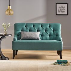 a blue couch sitting on top of a hard wood floor next to a table and lamp