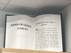 an open book sitting on top of a wooden shelf