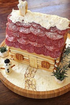 a cake made to look like a log cabin with meat and cheese on the roof