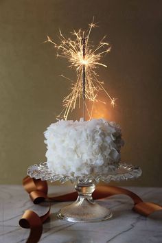 a cake with white frosting and sparklers on top