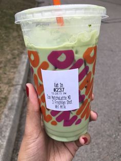 a person holding up a drink with a price tag on the cup in front of them