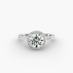 a round brilliant cut diamond ring with pave set shoulders and halos around the band