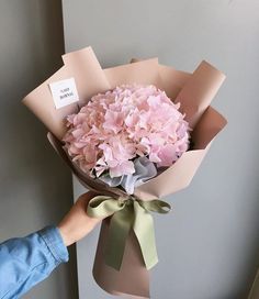 a person holding a bouquet of pink flowers