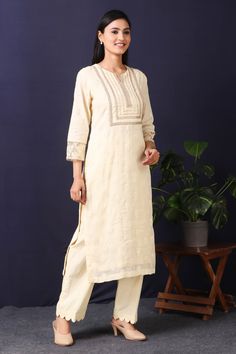 Stand out with this gorgeous mulmul cotton kurta in cream color with cotton stretch pants in a breezy and delicate cream tone featuring sequin and thread embroidery work with gota detailing on neckline. This beautiful mulmul cotton material outfit showcases beautiful sleeves with lace work on it offering a comfortable fit, making this outfit an absolute head-turner at parties. Style this set of kurta with a pair of diamond earrings and solid pumps to finish the look from Pure Elegance. Disclaimer: The actual product may vary slightly from the image. These are custom orders, hence expect slight variation in color, placement of the motif or buta. ESTIMATED DELIVERYBecause this is a custom order, it would take about 4 weeks from the date of purchase. RETURN POLICYThis product is a custom orde Cream Palazzo Set With Embroidered Border For Diwali, Cream Embroidered Palazzo Set For Eid, Cream Straight Kurta With Cutdana Details, Cream Chanderi Straight Kurta, Off White Straight Kurta Churidar, Cream Anarkali Cotton Palazzo Set, Cream Anarkali Style Cotton Palazzo Set, Elegant Cream Cotton Palazzo Set, Cream Chanderi Kurta With Gota Work