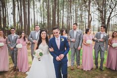 the bride and groom are surrounded by their bridal party in pink, gray and white