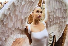 a woman is posing with an angel wings