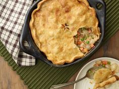 a casserole with meat and vegetables in it next to a bowl of mashed potatoes