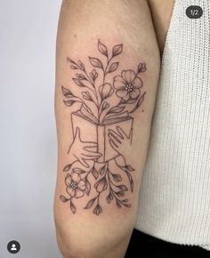 a woman's arm with a cross and flowers on it