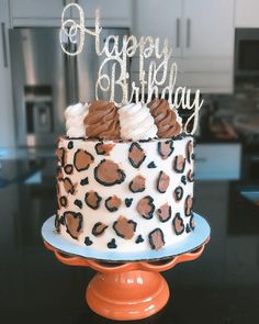 a leopard print cake with happy birthday written on top