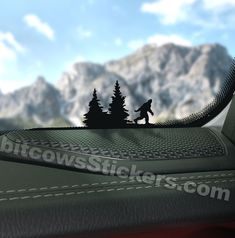 a car dashboard with the view of mountains and trees in the distance, as seen from behind